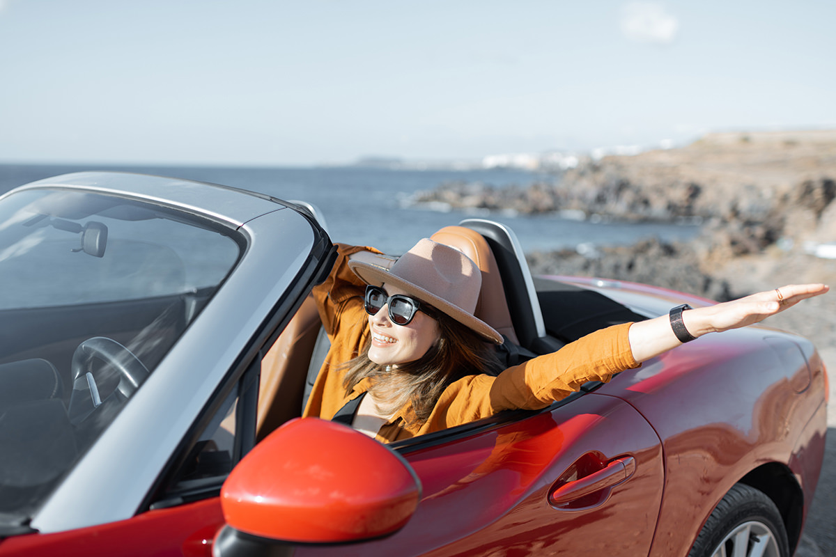 Driving a car is one of the best ways to explore Crete woman in convertible car driving