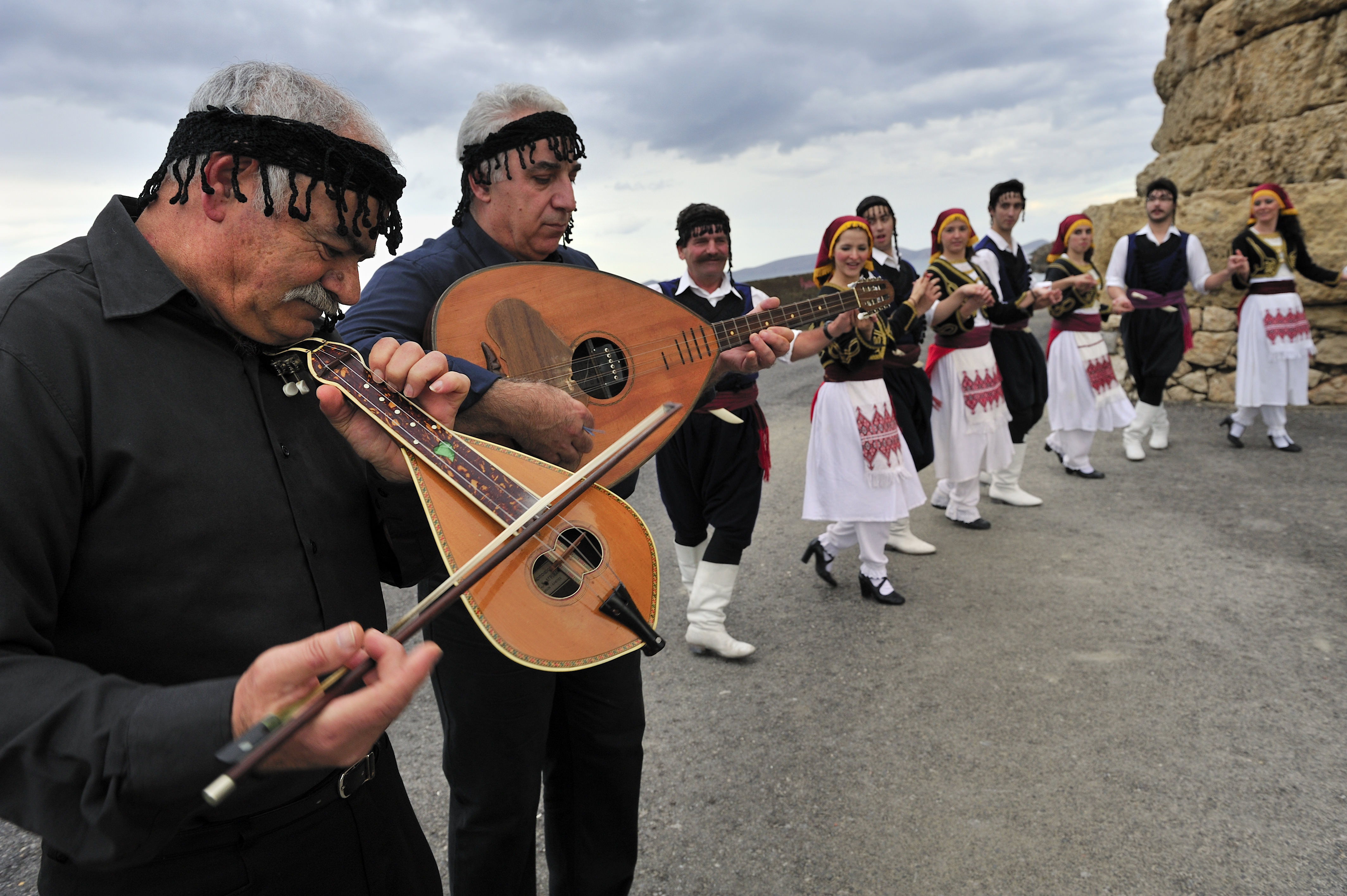 Cretan mantinades are a worldwide famous folk song type people playing traditional music and dancing